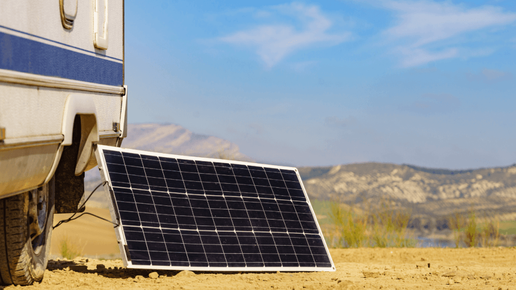 A campsite scene showing solar panels positioned next to a caravan, soaking up bright sunlight to supply eco-friendly power for lights, refrigerators, and other caravan equipment.